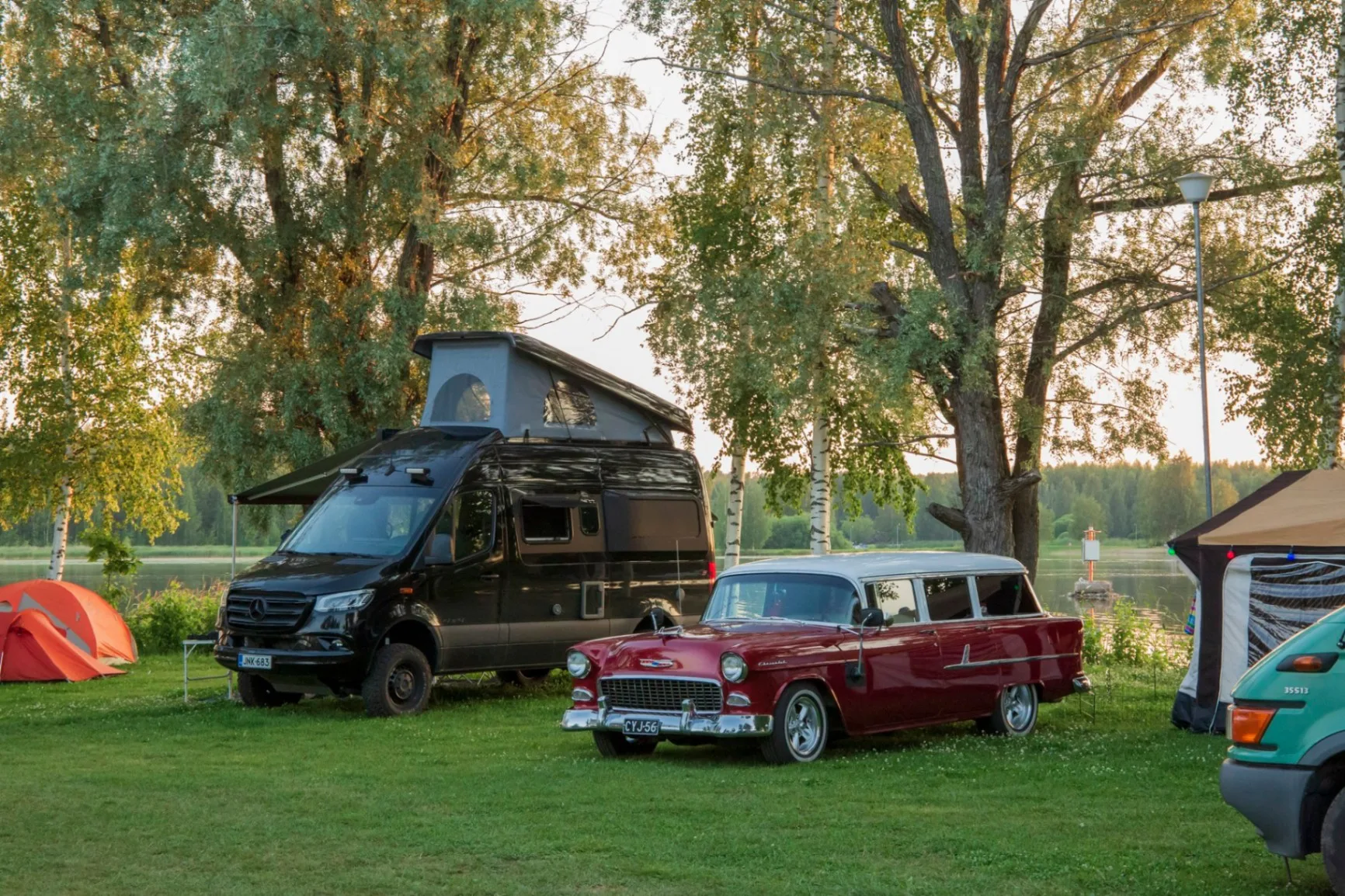 Retroauto ja retkeilyauto caravan-alueella järven rannalla